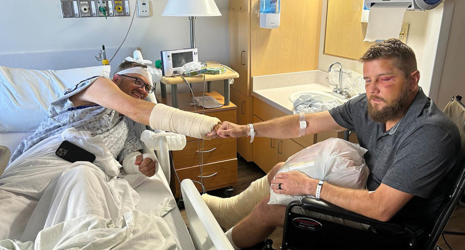 Aric Hutchinson sits in a wheelchair with his leg in a cast and eyes swollen.