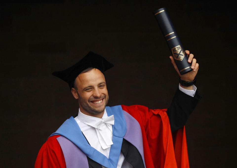 South African paralympian Oscar Pistorius poses for photographers after receiving an Honorary Doctorate at the University of Strathclyde in Glasgow, Scotland November 12, 2012. Pistorius was awarded the Doctorate for outstanding sporting success after competing in both the London 2012 Olympic and Paralympic Games. REUTERS/David Moir (BRITAIN - Tags: EDUCATION SPORT SOCIETY) - RTR3ABF5