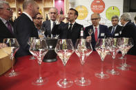 French President Emmanuel Macron drinks wine during a visit to the International Agriculture Fair (Salon de l'Agriculture) at the Porte de Versailles exhibition center in Paris, Saturday, Feb. 22, 2020. (Christophe Petit Tesson/Pool via AP)