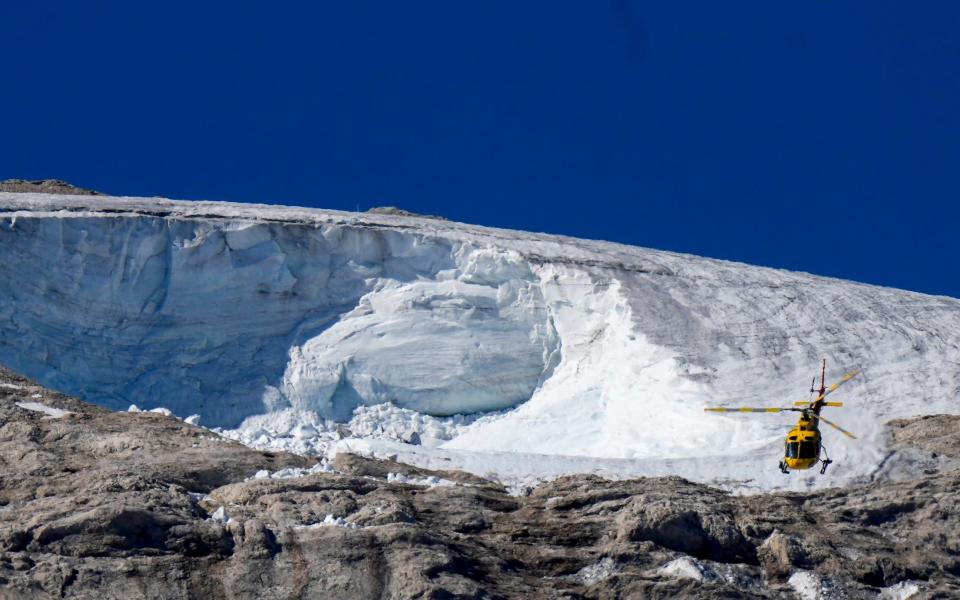 Un hélicoptère de sauvetage survole le glacier de Punta Rocca dans les Alpes italiennes du nord de l'Italie, où une avalanche a tué plusieurs randonneurs - Luca Bruno/AP