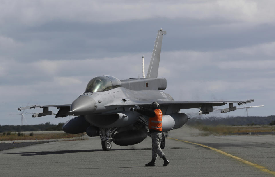 A Chilean air force F-16 fighter jet is directed on the tarmac as it arrives from searching for a missing C-130 Hercules transport plane, at the air base in Punta Arenas, Chile, Wednesday, Dec. 11, 2019. Searchers using planes, ships and satellites were combing the Drake Passage on Tuesday, hunting for the plane carrying 38 people that vanished en route to an Antartica base. (AP Photo/Fernando Llano)