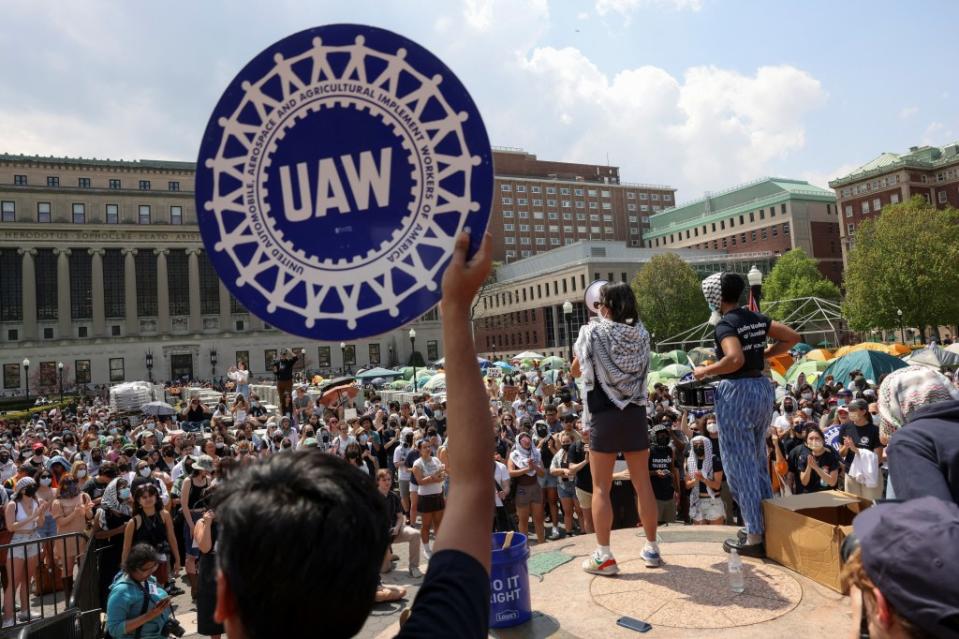 Students at a rally supporting Palestinians on the Columbia University campus hold signs and gather around an encampment, despite potential suspension. REUTERS