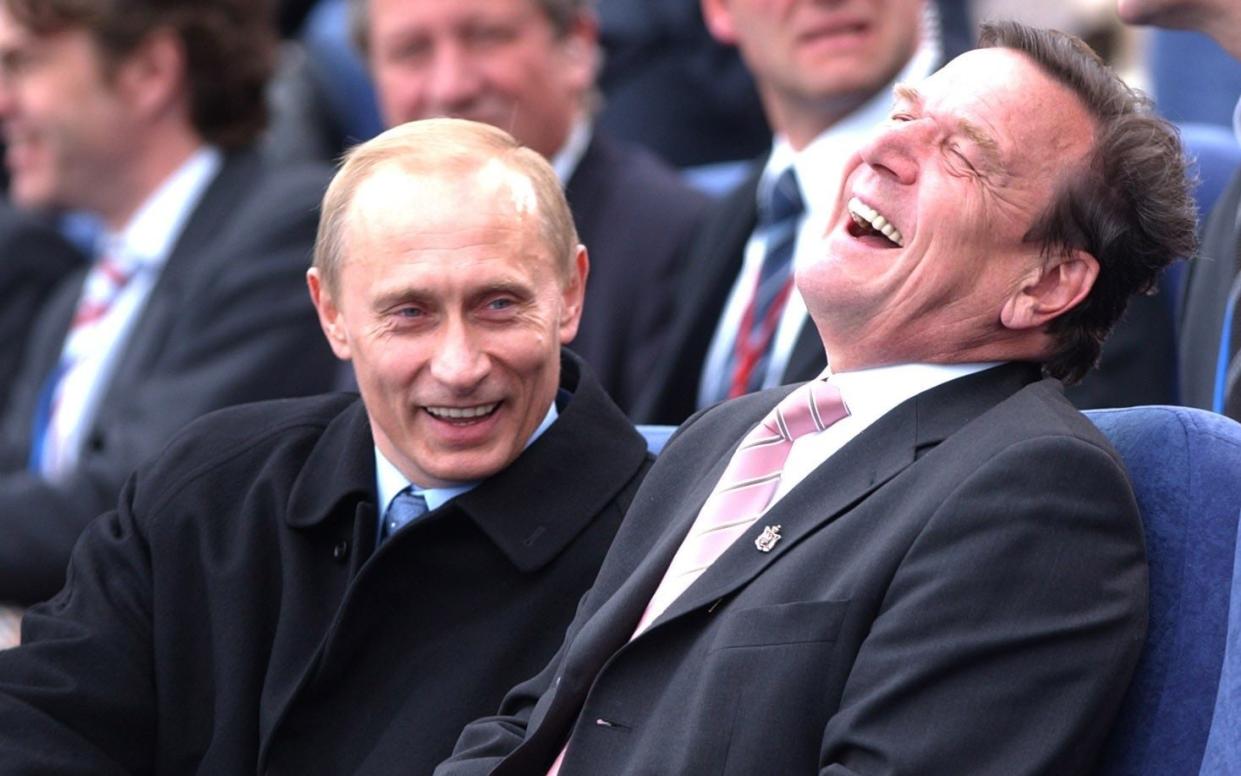 OLITICS Putin 2...Russian leader Vladamir Putin (left) shares a joke with German Chancellor Gerhard Schroder whilst they watched a festival on the river in St Petersburg, Russia, Saturday May 31, 2003, to celebrate the city's tercentenary. See PA story POLITICS Blair. PA Photo: Stefan Rousseau. - STEFAN ROUSSEAU/ PA
