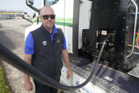 Tyrone Garrison plugs in a semi that is battery operated at the Indianapolis 500 auto race at Indianapolis Motor Speedway, Friday, May 20, 2022, in Indianapolis. (AP Photo/Darron Cummings)