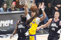 Los Angeles Clippers guard James Harden, left, shoots as Los Angeles Lakers center Jaxson Hayes, center, defends and center Mason Plumlee watches during the first half of an NBA basketball game Wednesday, Feb. 28, 2024, in Los Angeles. (AP Photo/Mark J. Terrill)