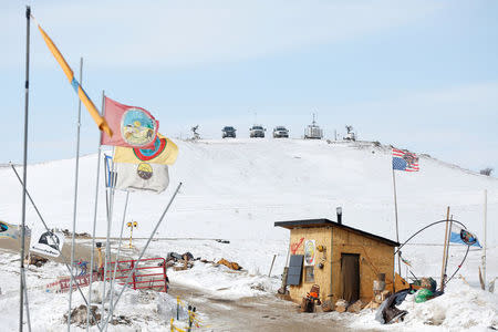 Police vehicles idle on the outskirts of the opposition camp against the Dakota Access oil pipeline near Cannon Ball, North Dakota, U.S., February 8, 2017. REUTERS/Terray Sylvester