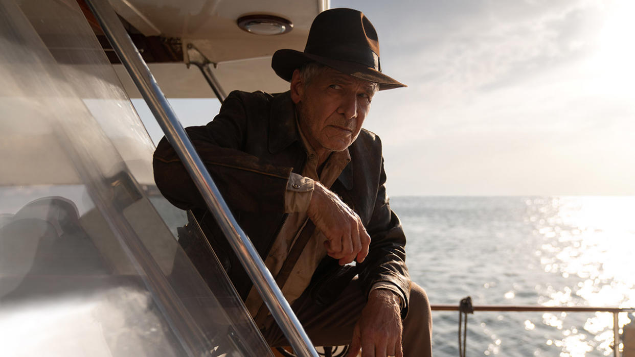  Still from the movie Indiana Jones and the Dial of Destiny. Here we see Indiana Jones casually leaning forward on a yacht. 