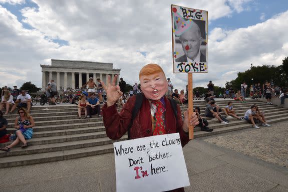 A masked fan of the US rap group Insane Clown Posse, known as Juggalos, holds placards during a protest on September 16, 2017 near the Lincoln Memorial in Washington, D.C. against a 2011 FBI decision to classify their movement as a gang. / AFP PHOTO / Paul J. Richards        (Photo credit should read PAUL J. RICHARDS/AFP/Getty Images)