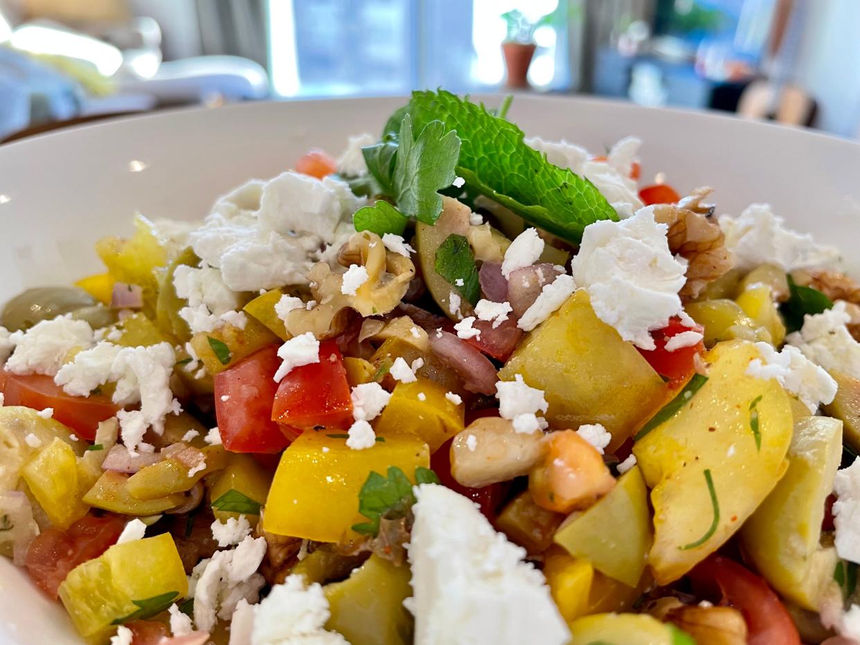 A close-up of an olive salad sprinkled with feta cheese.