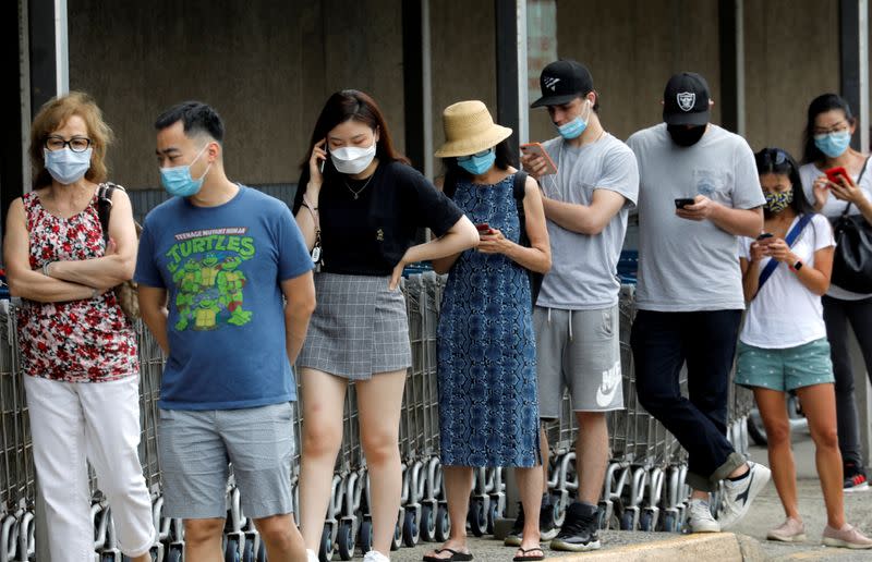 FILE PHOTO: People wear protective face masks outside at a shopping plaza in Edgewater, New Jersey