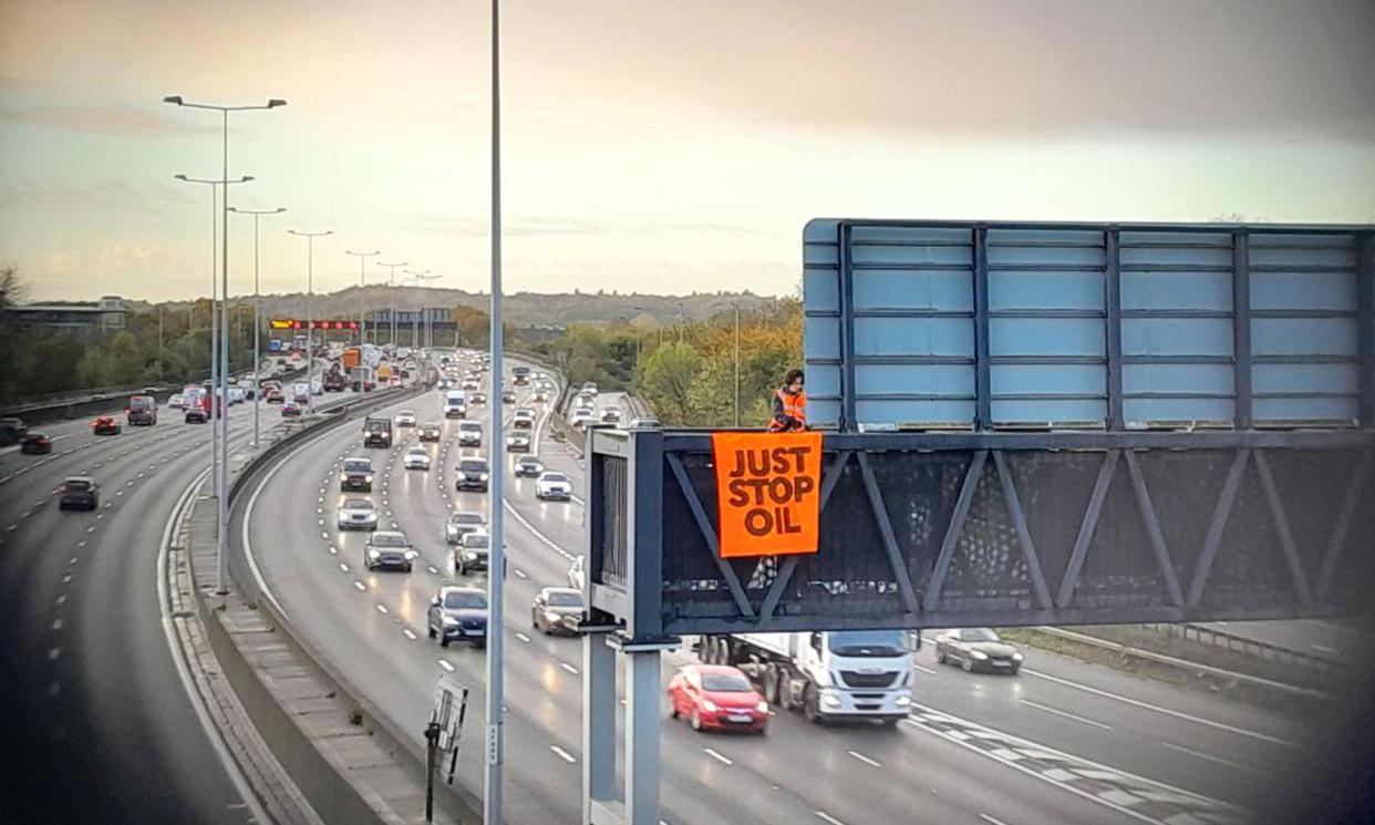 <span>A Just Stop Oil protest on an overhead gantry of the M25 near London in November 2022.</span><span>Photograph: Just Stop Oil/PA</span>