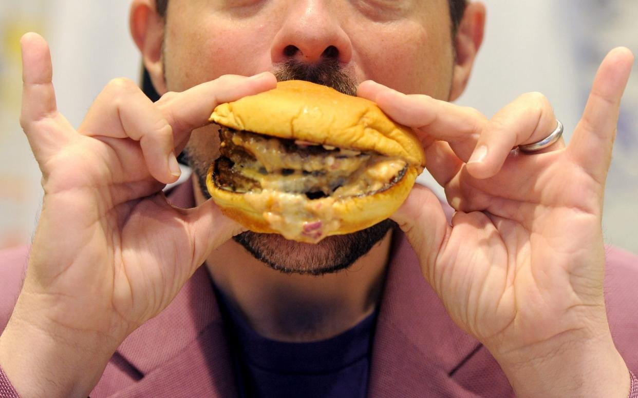 A man eats a burger - Getty Images