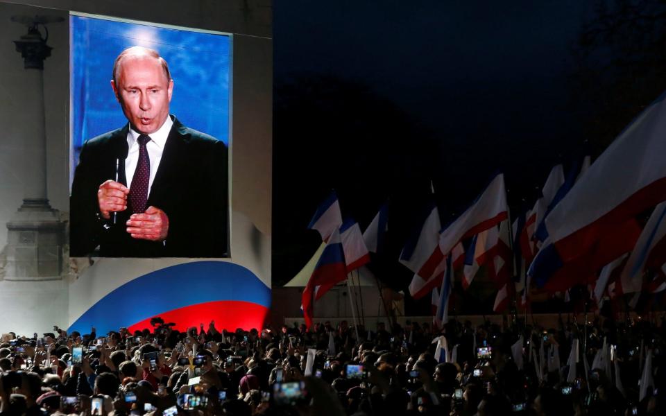 Russian president Vladimir Putin addresses the audience during a rally marking the fourth anniversary of Russia's annexation of Ukraine's Crimea region in the Black Sea port of Sevastopol - REUTERS