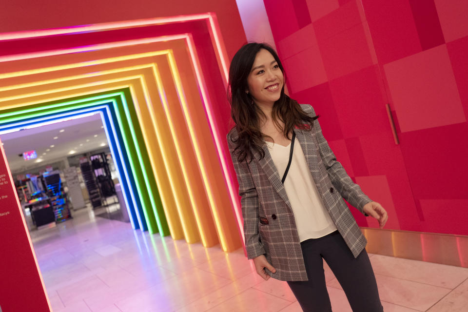 Yoli Ho poses for photos at the entrance to Story on its opening day at Macy's, Wednesday, April 10, 2019, in New York. A year after buying startup Story, Macy's is bringing to life the retail concept to 36 stores in 15 states including its Manhattan flagship store. (AP Photo/Mark Lennihan)