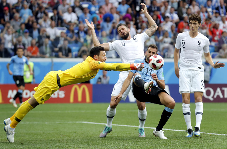 <p>France goalkeeper Hugo Lloris, front left, and Uruguay’s Cristhian Stuani, front right, challenge for the ball. </p>