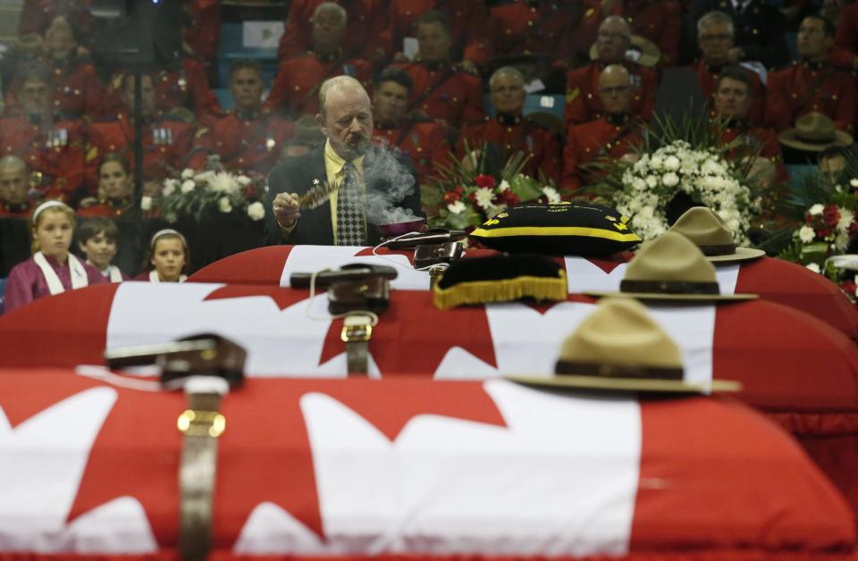 A smudging ceremony is performed over the casket of RCMP Constable Fabrice Georges Gevaudan, one of three officers who were killed last week, during a regimental funeral in Moncton