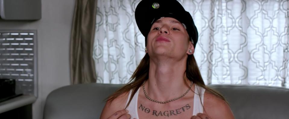 A man with a tattoo that says "No ragrets"