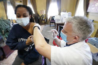 Walgreens pharmacist Chris McLaurin prepares to vaccinate Lakandra McNealy, a Harmony Court Assisted Living employee, with the Pfizer-BioNTech COVID-19 vaccine, Tuesday, Jan. 12, 2021, in Jackson, Miss. The Mississippi State Department of Health reports there have been 9,796 cases of the coronavirus in long-term care facilities and 1,791 deaths as of Tuesday. (AP Photo/Rogelio V. Solis)