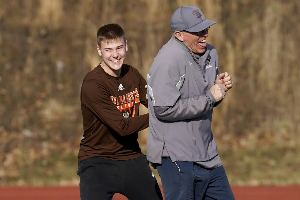 East Palestine High School senior Owen Elliott reaches head coach Bill Sattler during baserunning drills during baseball practice, Monday, March 6, 2023, in East Palestine, Ohio. Athletes are navigating spring sports following the Feb. 3 Norfolk Southern freight train derailment. (AP Photo/Matt Freed)