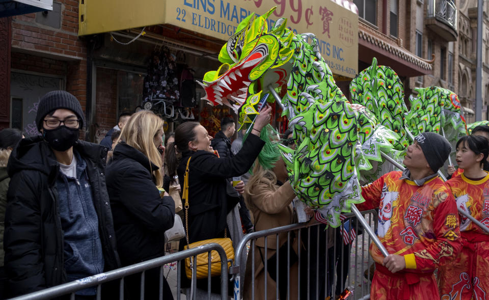 Participants with a dragon caricature mingle with revelers during the Lunar New Year parade in the Chinatown neighborhood of New York, Sunday, Feb. 9, 2020. (AP Photo/Craig Ruttle)