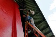 Cuban migrant Barbaro Rodriguez, 43, who run out of money, works painting a private business in Paso Canoas on the border with Costa Rica March 22, 2016. REUTERS/Carlos Jasso