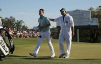 Justin Rose of England gets a pat on his back from his caddie Mark Fulcher after finishing his round on the 18th green in third round play during the 2017 Masters golf tournament at Augusta National Golf Club in Augusta, Georgia, U.S., April 8, 2017. REUTERS/Brian Snyder