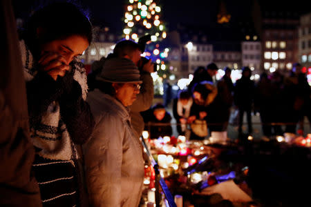 People cry as they light candles in tribute to the victims of the deadly shooting in Strasbourg, France, December 13, 2018. REUTERS/Christian Hartmann