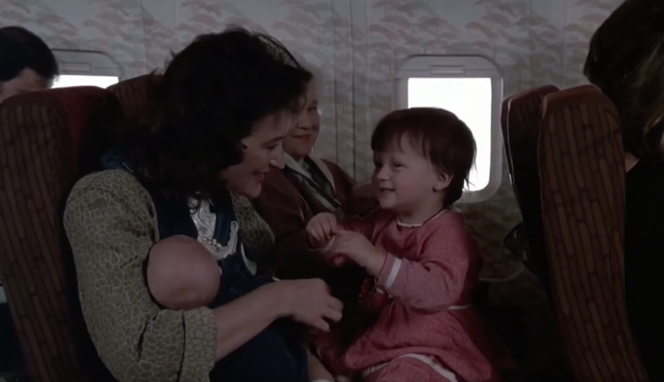 Streep holding a baby Mamie on her lap on an airplane in "Heartburn"