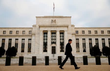 A man walks past the Federal Reserve Bank in Washington, D.C., U.S. December 16, 2015. REUTERS/Kevin Lamarque/File Photo