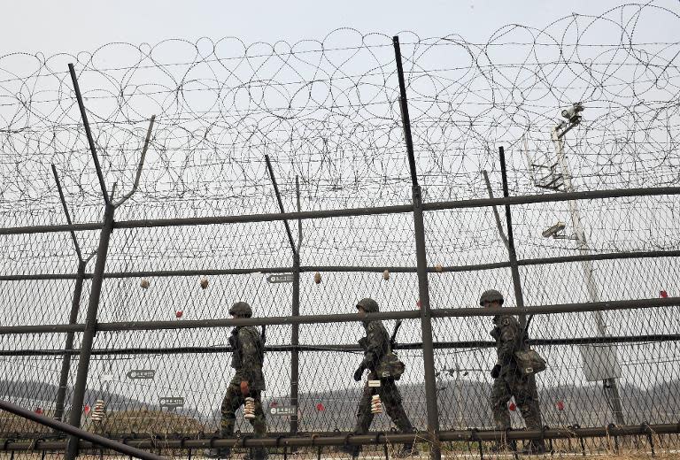 South Korean soldiers patrol along a military fence near the Demilitarized Zone (DMZ) dividing the two Koreas in the border city of Paju on April 16, 2013