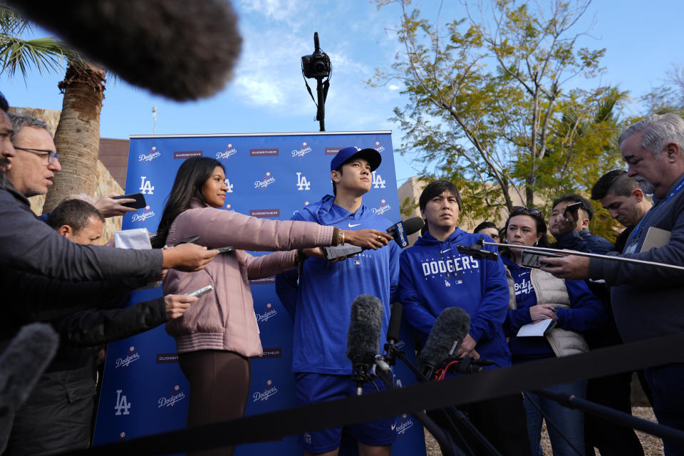 Los Angeles Dodgers' Shohei Ohtani, with interpreter Ippei Mizuhara, right, listens to a question as he speaks to media at Camelback Ranch in Phoenix, Friday, Feb. 9, 2024, on the first day of spring training baseball workouts for the Dodgers. (AP Photo/Carolyn Kaster)