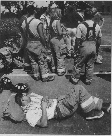 A firefighter rests after contributing to the efforts of fighting a building collapse and resulting fire at Quad Graphics in Lomira, which lasted nine days in the summer of 2002.