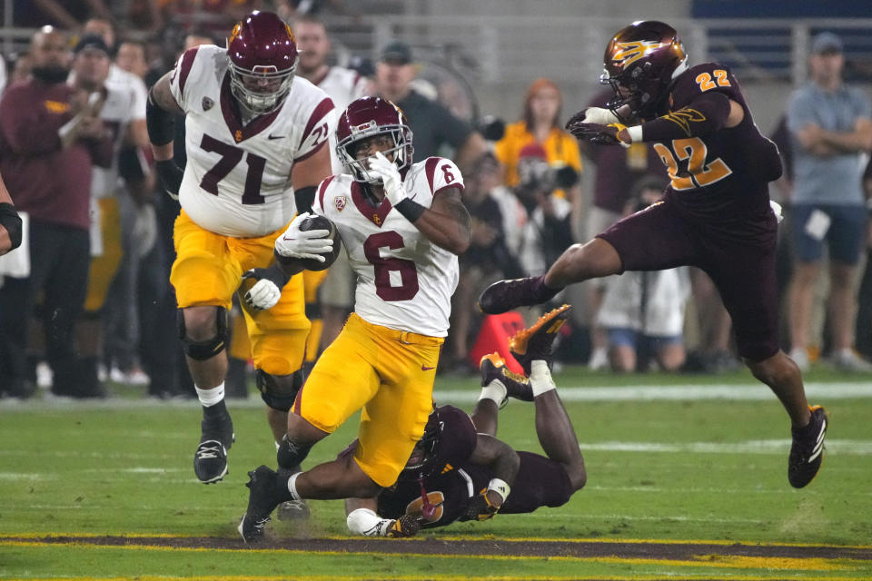 Southern California running back Austin Jones (6) breaks away from Arizona State defensive back Ro Torrence and linebacker Caleb McCullough (22) during the first half of an NCAA college football game, Saturday, Sept. 23, 2023, in Tempe, Ariz. (AP Photo/Rick Scuteri)