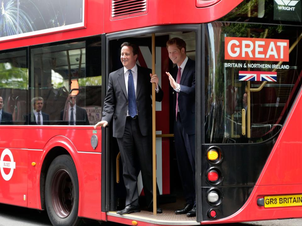 Prince Harry and David Cameron ride a bus in 2013.