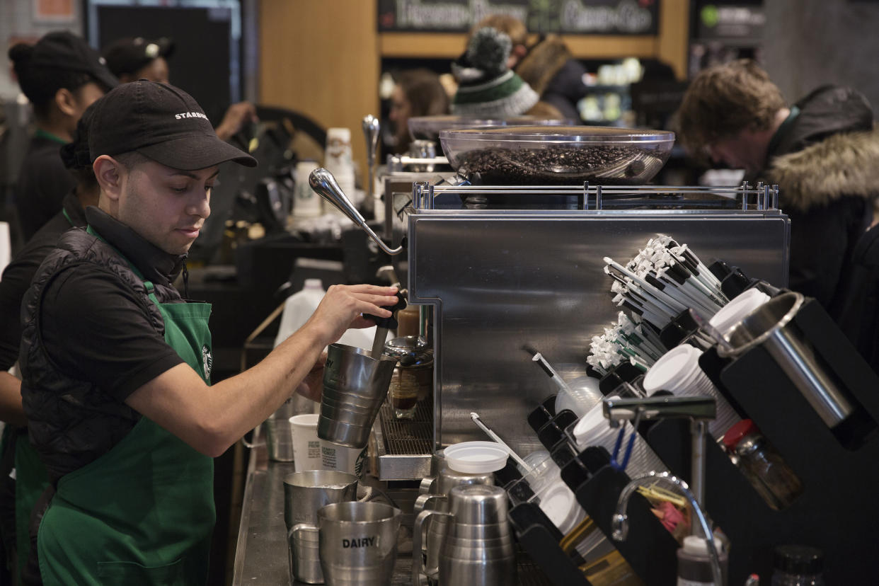 A barista froths milk for a drink inside a Starbucks shop in New York. Shareholders of the company are criticizing&nbsp;how its employee benefits are different for hourly workers and salaried workers. (Photo: Bloomberg via Getty Images)