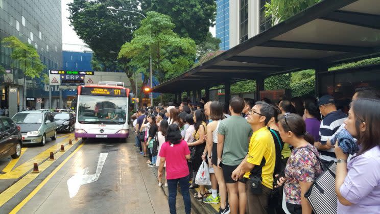 Commuters affected by the disruption on the North-South Line waiting for free bus services near Orchard MRT station on the evening of 28 June 2017. Photo: Teng Yong Ping/Yahoo Singapore