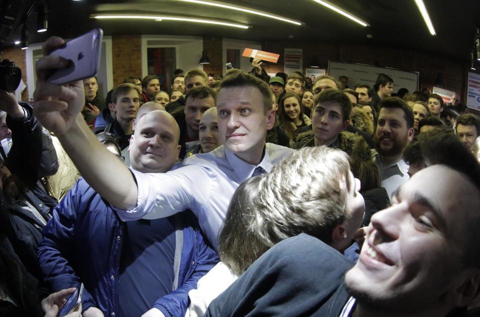 Russian opposition leader Alexei Navalny takes a selfie with his supporters at the opening of his campaign office in St. Petersburg, Russia, Saturday, Feb. 4, 2017. Alexei Navalny, Russia's most prominent opposition figure, has opened his first regional office for a presidential bid, despite an imminent court verdict that could bar him from running.(AP Photo/Elena Ignatyeva)