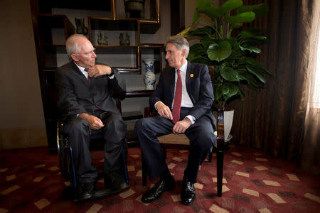 Britain's Chancellor of the Exchequer Philip Hammond (R) chats with Wolfgang Schauble, Geramny's Federal Minister of Finance before a private lunch on the sidelines of the G20 High-level Tax Symposium held in Chengdu in Southwestern China's Sichuan province, Saturday, July 23, 2016. REUTERS/Ng Han Guan/Pool