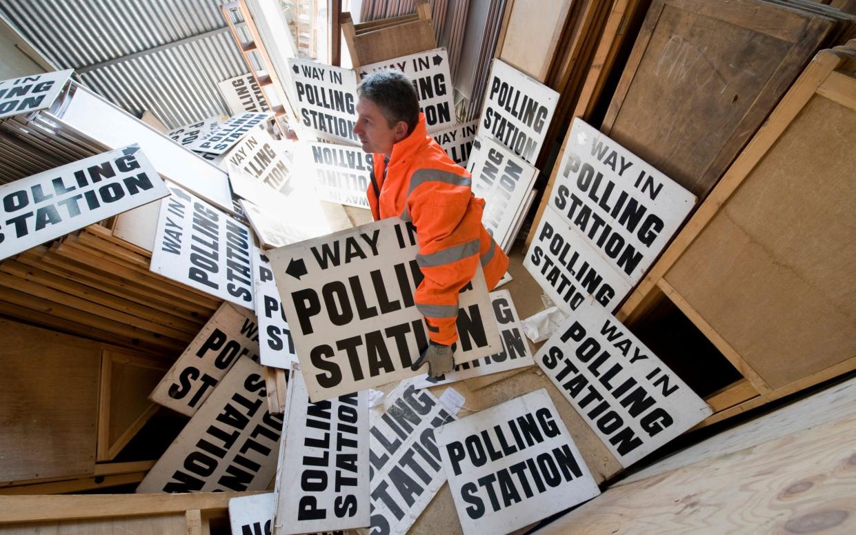 A polling official sorts out signs