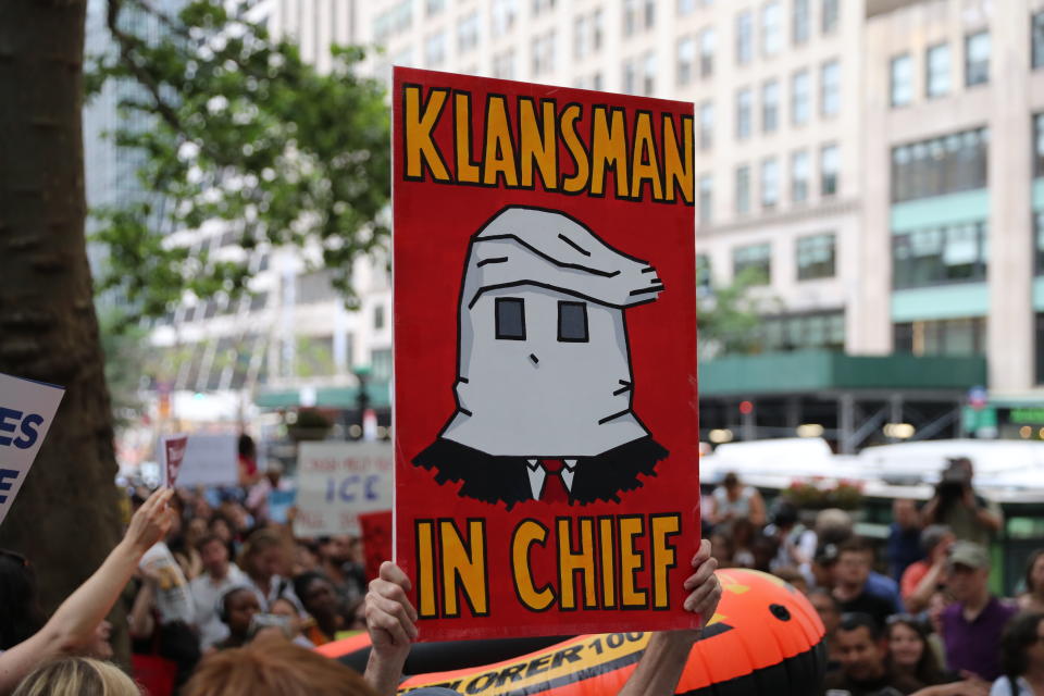 <p>A protester holds up a sign depicting President Trump as a member of the KKK and reading “Klansman in Chief” on the terrace outside the New York Public Library on 42nd Street in New York City on June 20, 2018. (Photo: Gordon Donovan/Yahoo News) </p>
