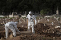 Cemetery workers in protective clothing maneuver the coffin of 57-year-old Paulo Jose da Silva, who died from the new coronavirus, in Rio de Janeiro, Brazil, Friday, June 5, 2020. According to Monique dos Santos, her stepfather mocked the existence of the virus, didn't use a mask, didn't take care of himself, and wanted to shake hands with everybody. "He didn't believe in it and unfortunately he met this end. It's very sad, but that's the truth," she said. (AP Photo/Leo Correa)