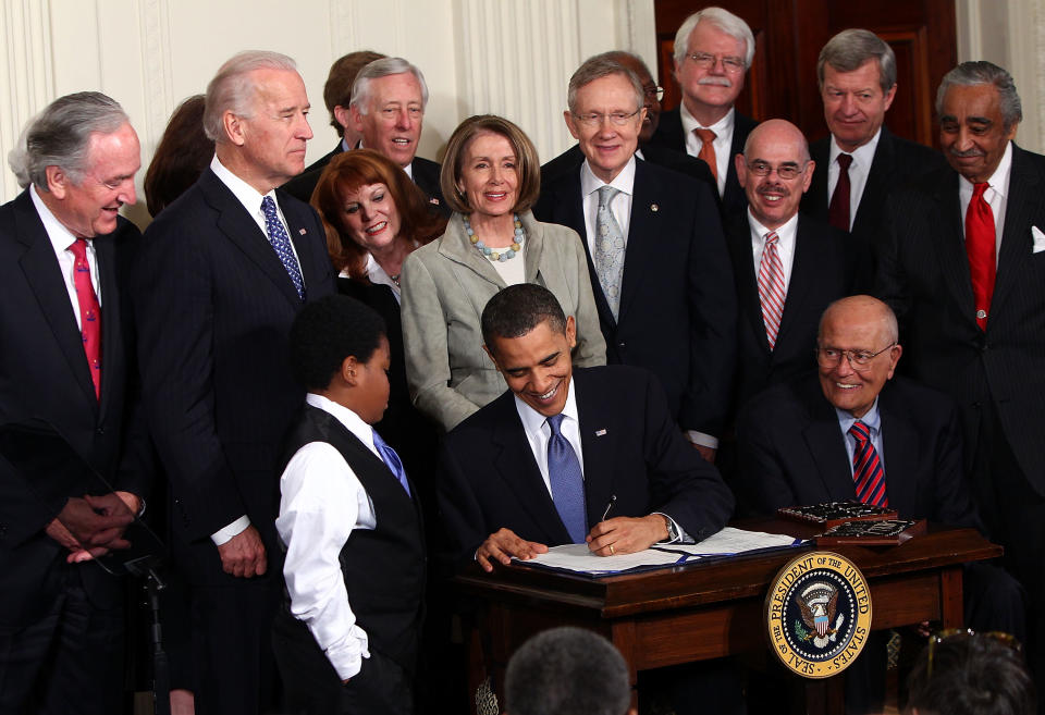 U.S. President Barack Obama (C) signs the Affordable Health Care for America Act during a ceremony with fellow Democrats on March 23, 2010. (Photo by Win McNamee/Getty Images) 