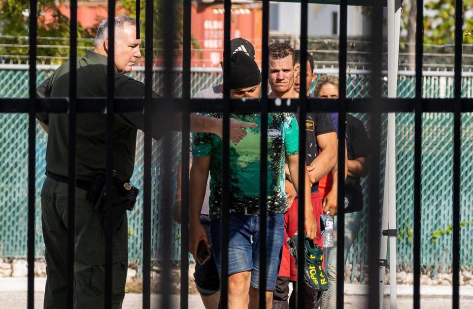 An officer directs a group of Cuban migrants at the U.S. Customs and Border Protection office on Sunday, Jan. 8, 2023, in Marathon, Fla.