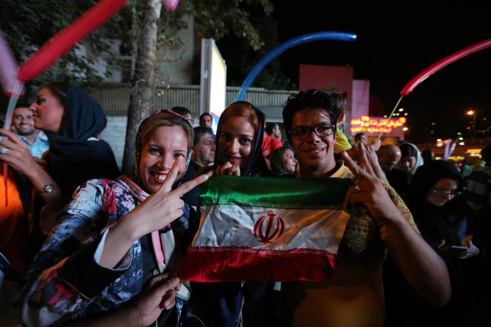 Iranian women wave the national flag and flash the v sign for victory during celebration in northern Tehran on July 14, 2015, after Iran's nuclear negotiating team struck a deal with world powers in Vienna. 