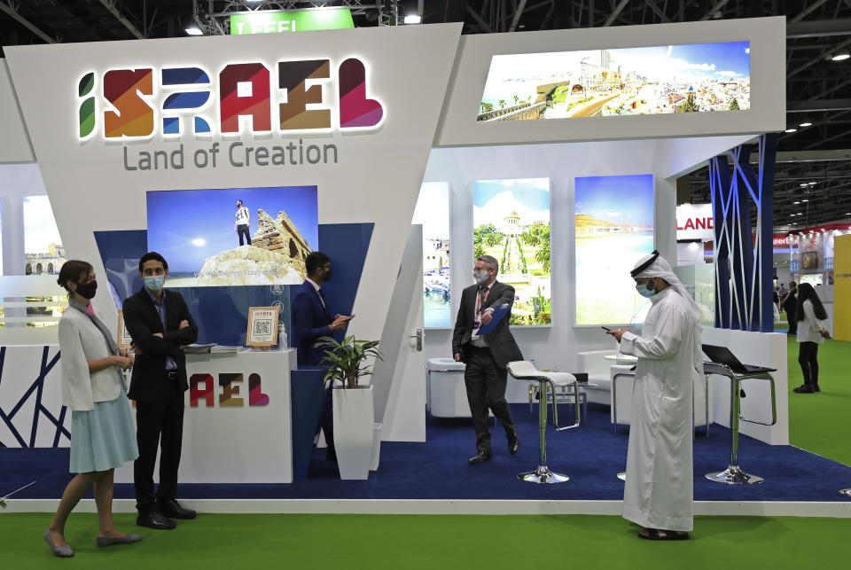 Israeli exhibitors receive visitors at their stand on the opening day of the Arabian Travel Market exhibition, in Dubai, United Arab Emirates, Sunday, May 16, 2021. As violence flares within Israel and on a day in which Israeli airstrikes on Gaza City killed at least 42 people Sunday, it was business as usual for a senior Israeli tourism official in Dubai as she promoted the country as a must-see destination for Muslim visitors. (AP Photo/Kamran Jebreili)