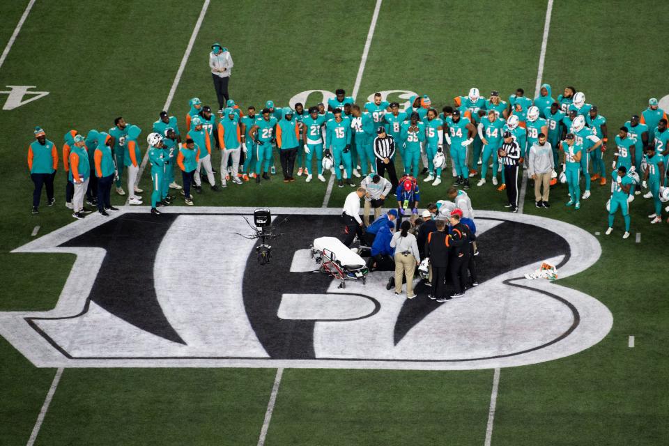 Teammates gather around Miami Dolphins quarterback Tua Tagovailoa after an injury Thursday night.