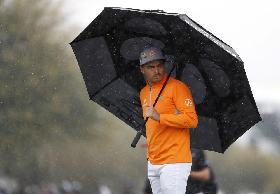 Rickie Fowler tries to keep dry on the 11th green during the final round of the Phoenix Open PGA golf tournament, Sunday, Feb. 3, 2019, in Scottsdale, Ariz. (AP Photo/Matt York)