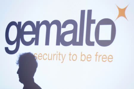 FILE PHOTO: The shadow of an attendee is cast below a logo of Franco-Dutch technology firm Gemalto during a news conference in Paris February 25, 2015. REUTERS/Gonzalo Fuentes