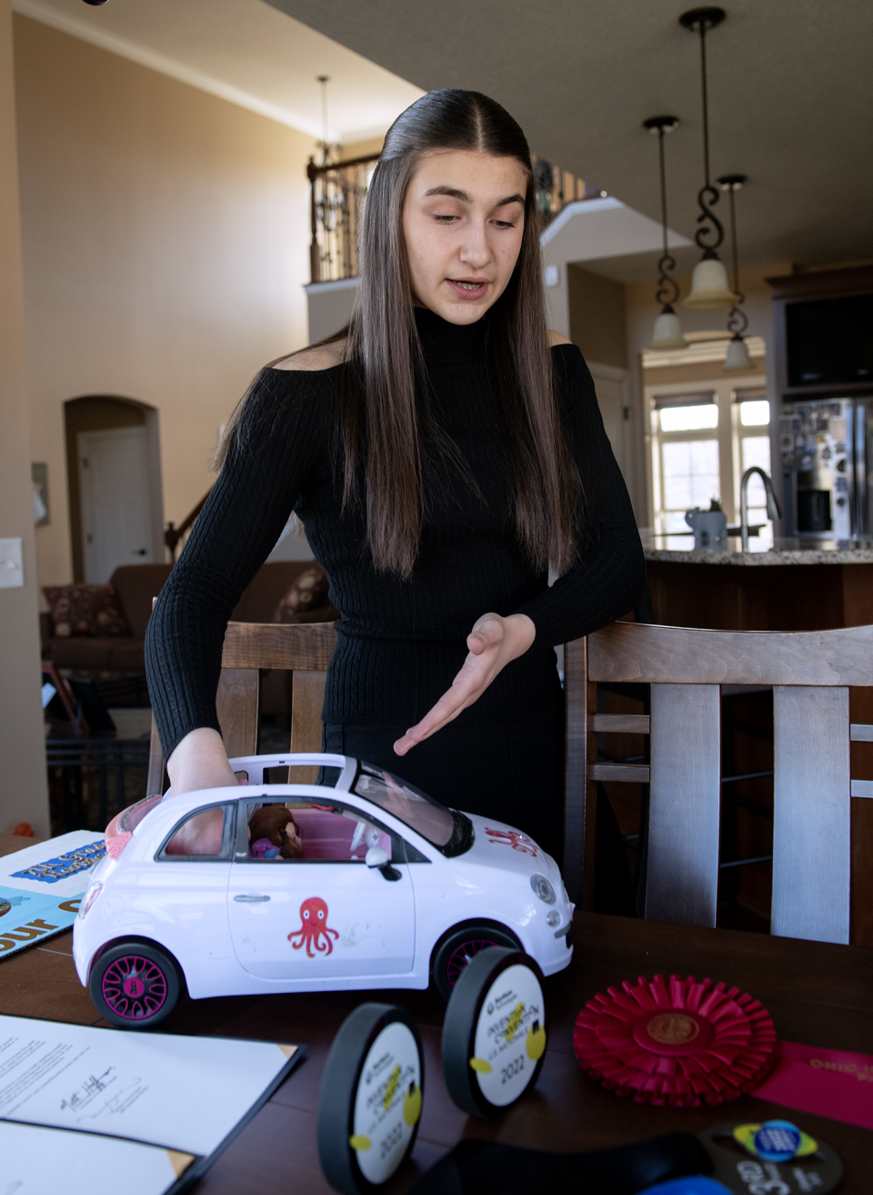 Ava-Elizabeth Bell, at her home in Rootstown, explains her OCT-D Defense For Your Car invention.