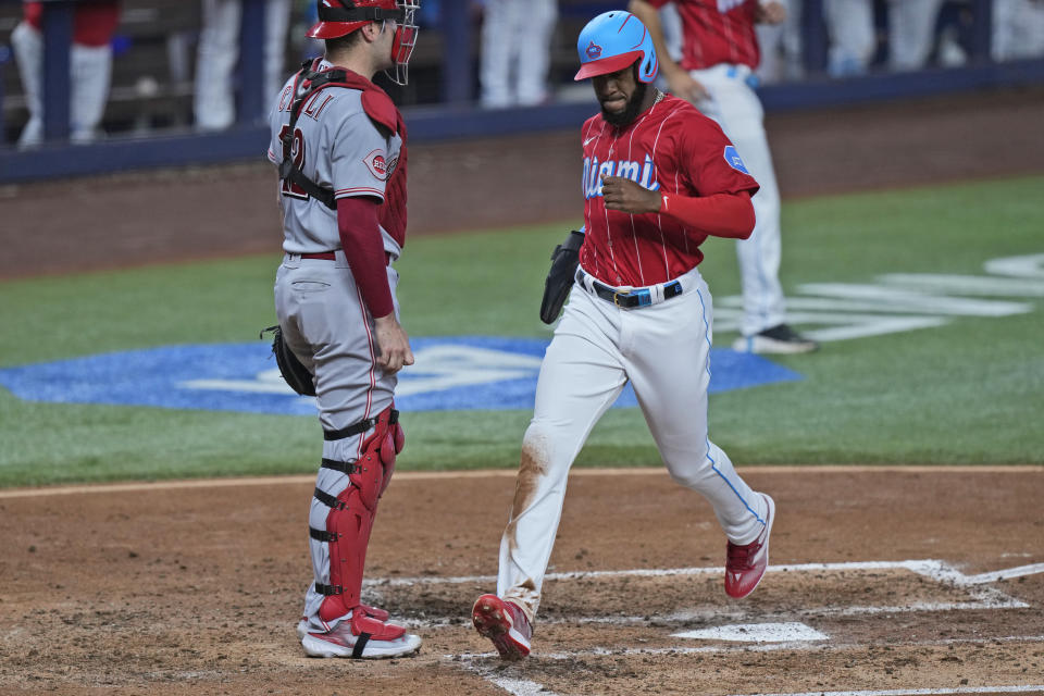 Miami Marlins' Bryan De La Cruz scores on a single by Yuli Gurriel during the fourth inning of a baseball game against the Cincinnati Reds, Saturday, May 13, 2023, in Miami. (AP Photo/Wilfredo Lee)